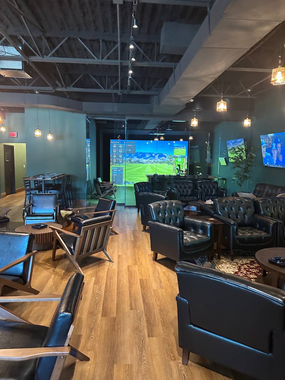 Chairman’s Club cigar lounge seating with indoor golf simulator in Farmington Hills